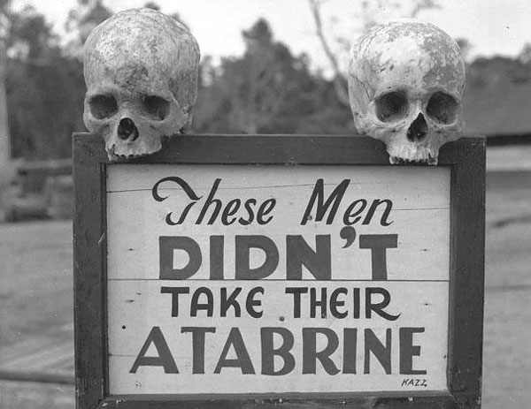 Una pubblicità macabra dell’Atabrine, un farmaco contro la malaria usato durante la seconda guerra mondiale. Il cartello recita: “Questi uomini non hanno preso la loro Atabrine”